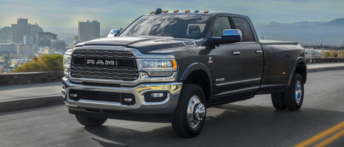 2024 Ram 3500 pickup truck driving with a city skyline in the background